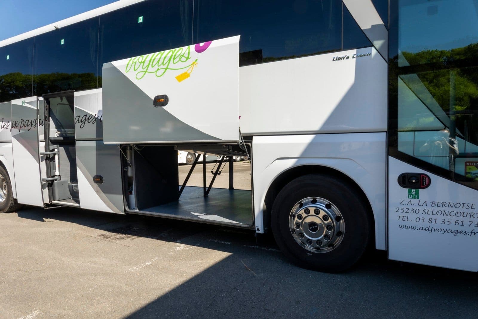 Autocar ADJ Voyages soutes ouvertes, vu de trois quarts avant