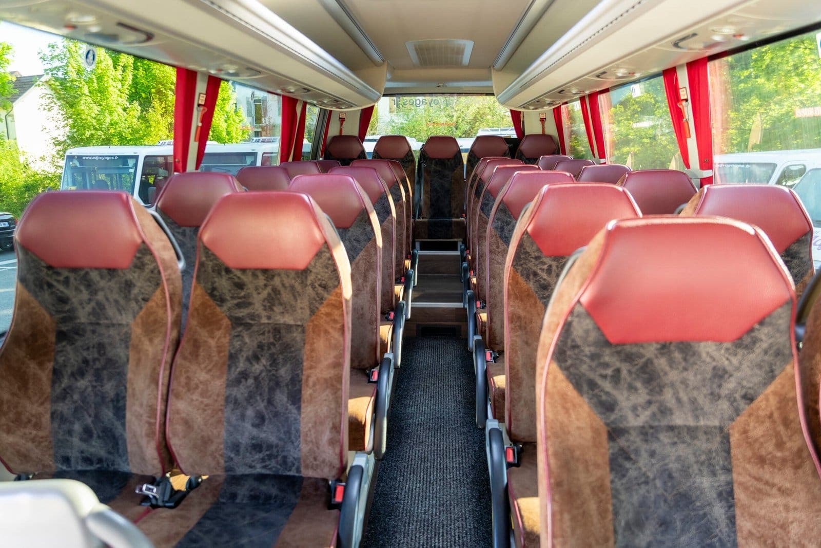 Allée centrale et sièges rouges d'un autocar de tourisme ADJ Voyages