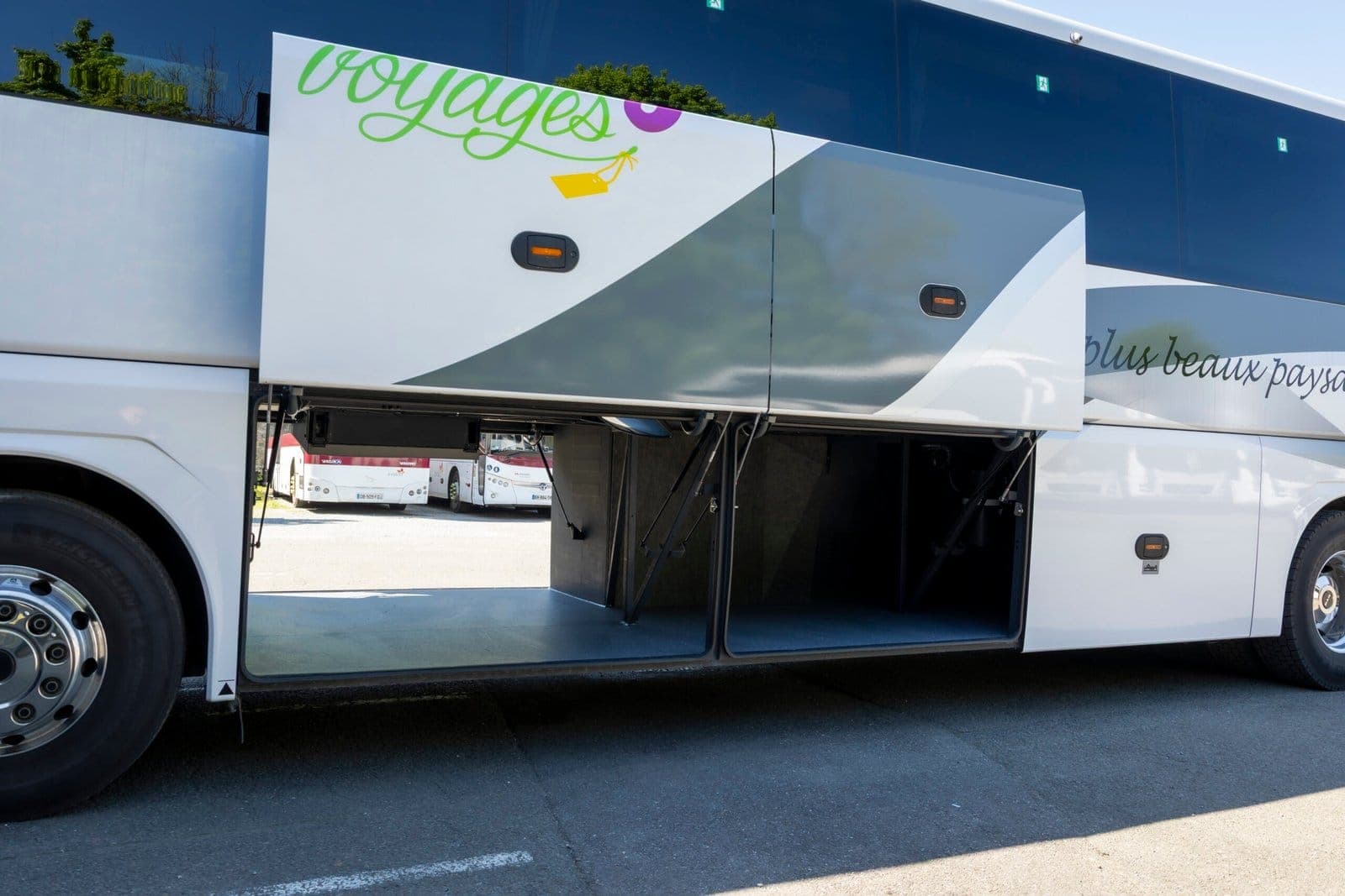 Soute à bagages ouverte sur le flanc d'un autocar de grand tourisme ADJ Voyages