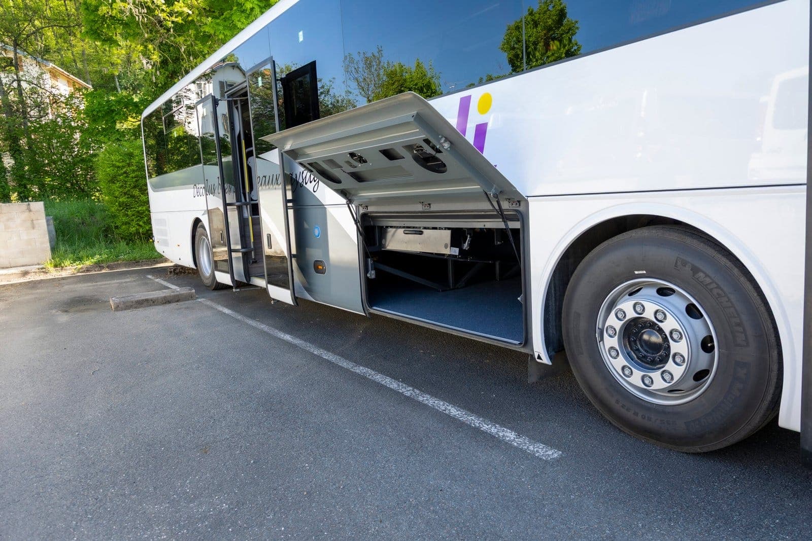 Autocar scolaire ADJ Voyages soutes ouvertes sur le dépôt