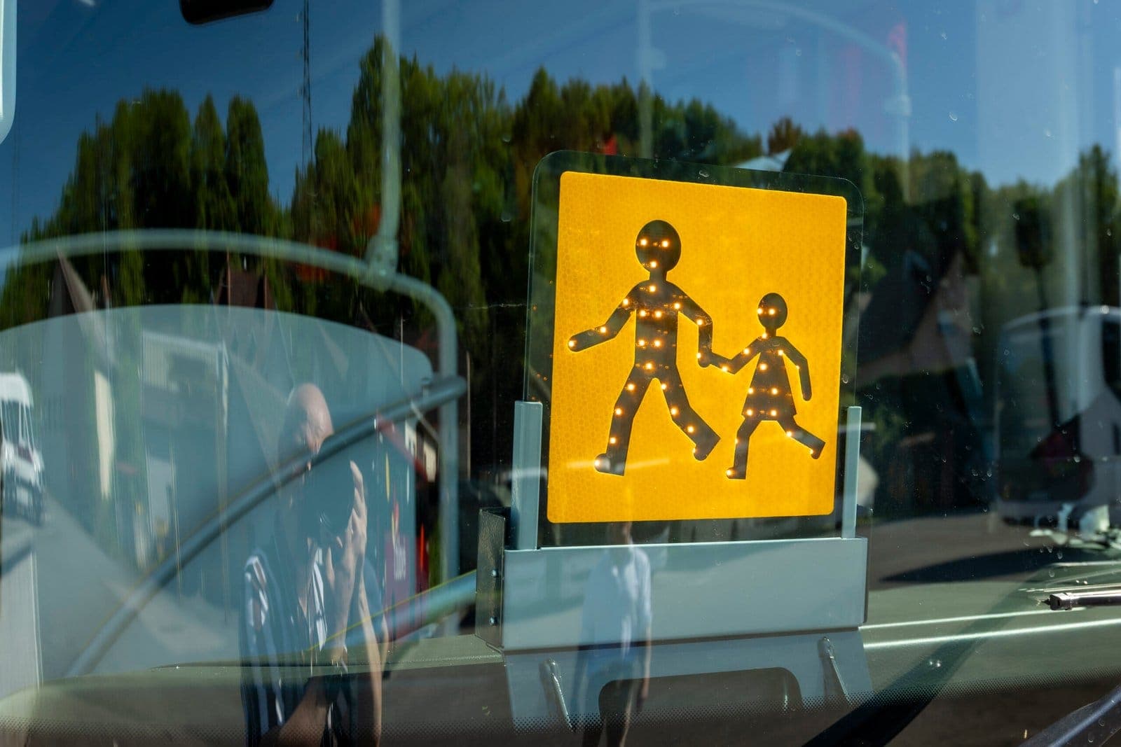 Panneau de signalisation « transport d'enfants » affiché derrière le pare-brise d'un autocar ADJ Voyages