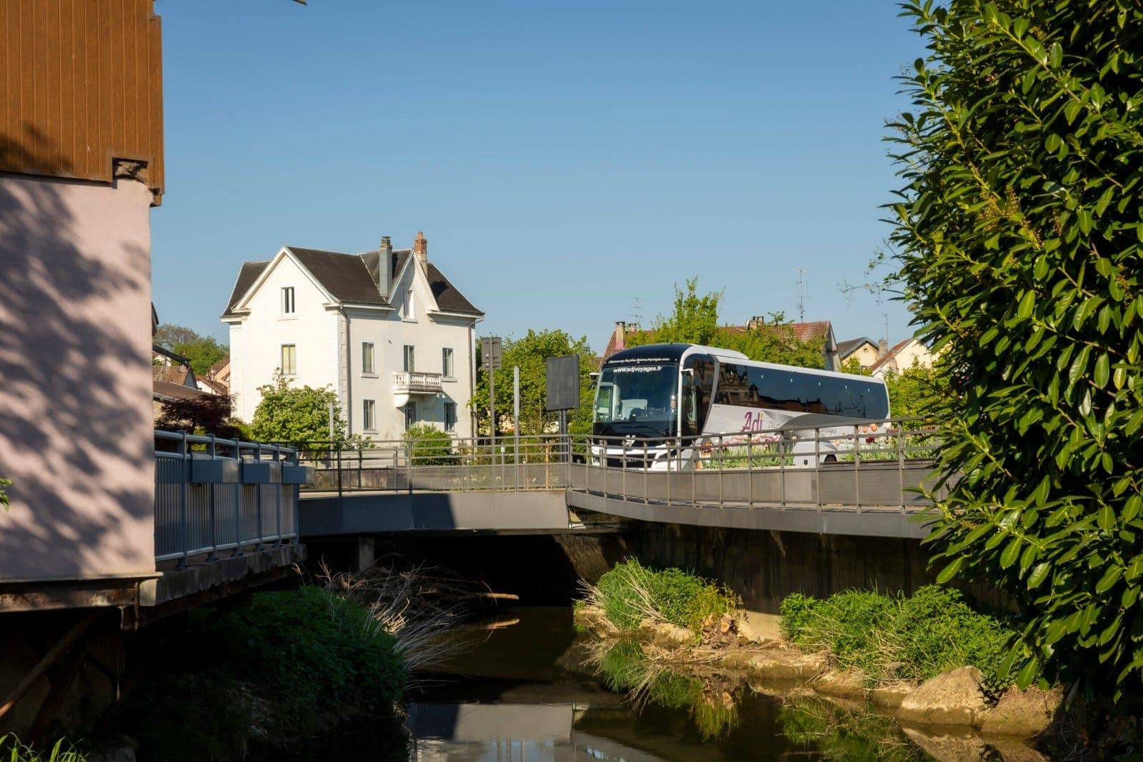 Autocar MAN ADJ Voyages franchissant un pont au-dessus d’une rivière