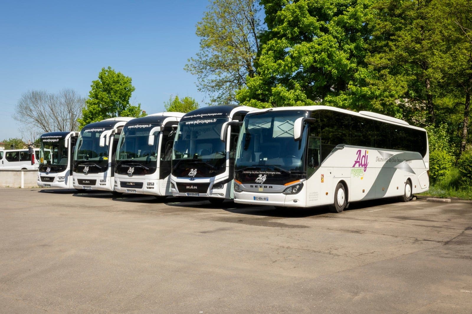 Flotte d'autocars Setra et MAN d'ADJ Voyages alignés sur le parking du dépôt