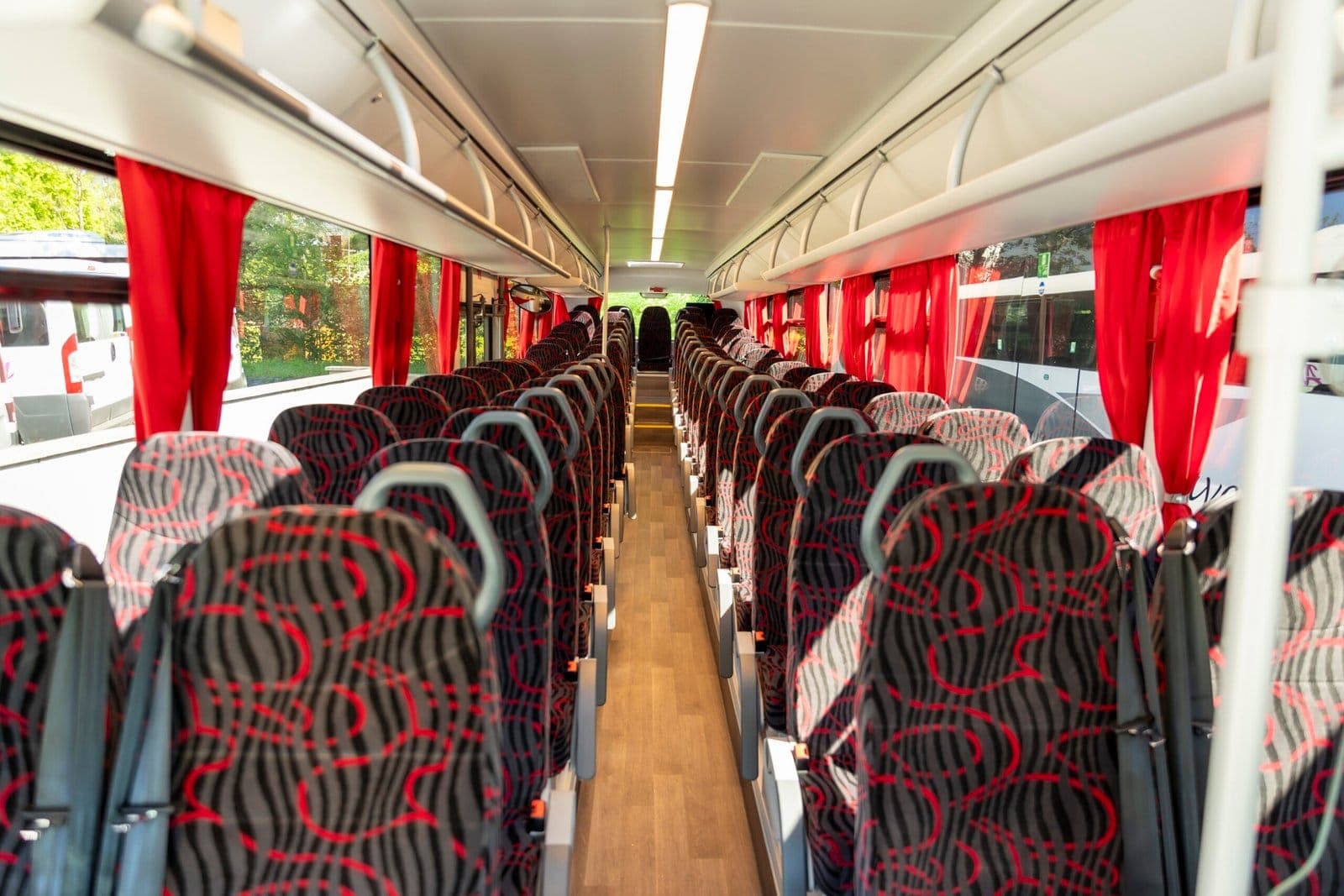 Intérieur d'autocar ADJ Voyages avec sièges rouge et noir