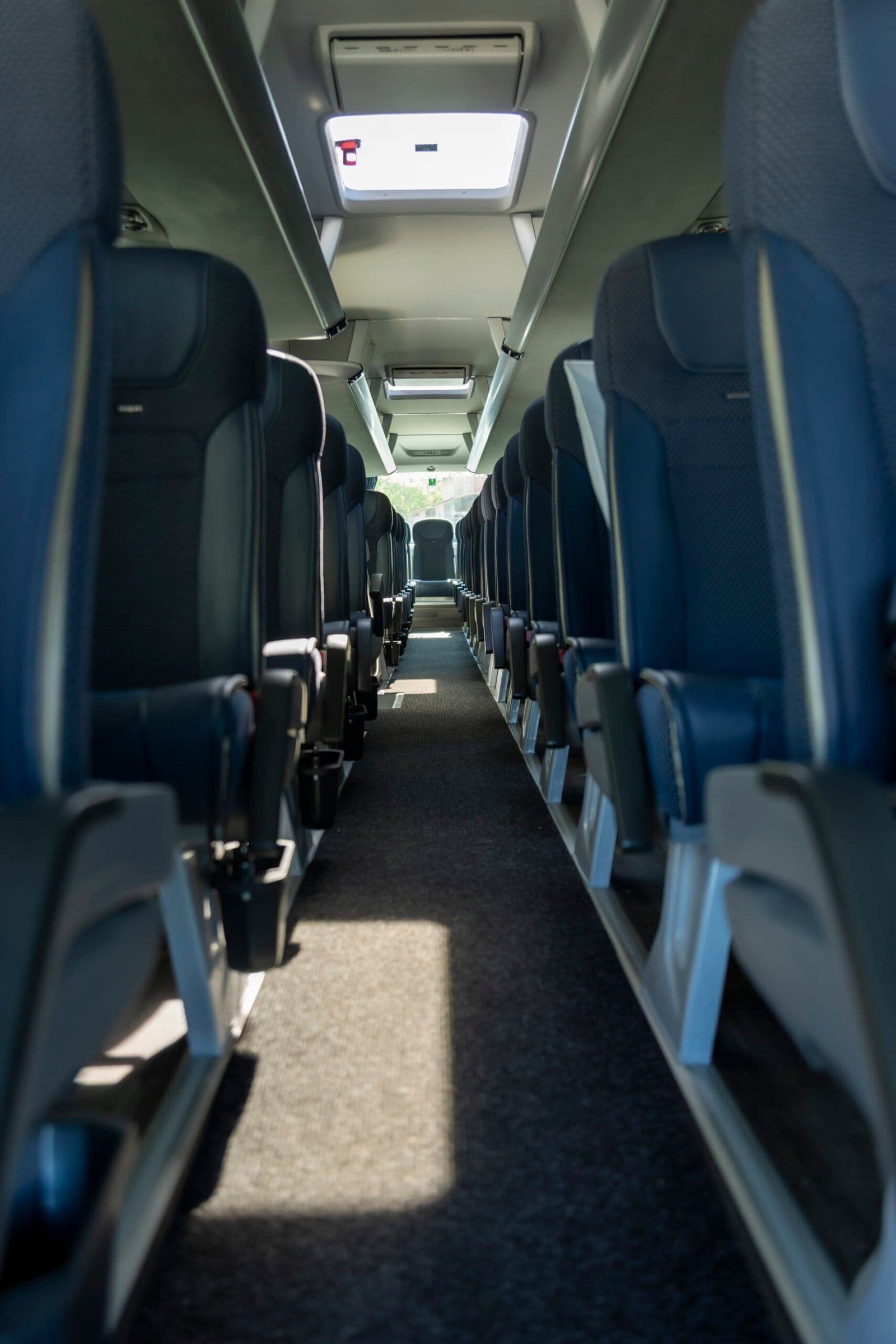 Allée centrale et sièges bleus d’un autocar de grand tourisme ADJ Voyages